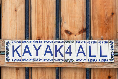 Close-up of information sign on wooden door