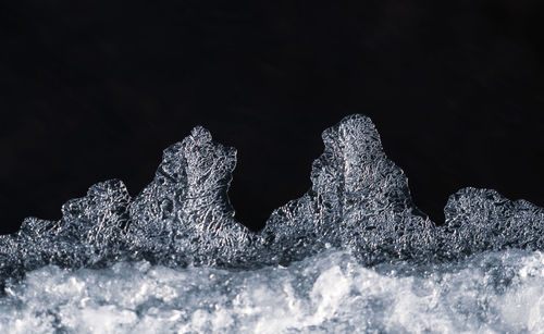 Close-up of frozen water against black background