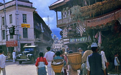 People on street amidst buildings in city