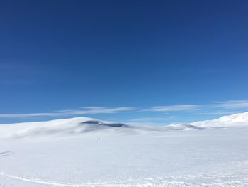 Scenic view of snow mountains against blue sky
