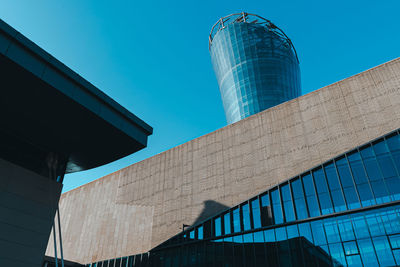 Low angle view of modern building against blue sky