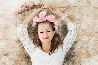 Mid adult woman with eyes closed standing against wall