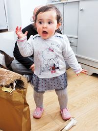Portrait of boy standing on hardwood floor