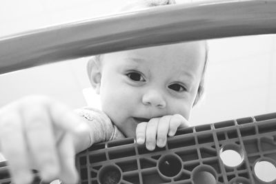 Portrait of cute baby seen through shopping cart at super market