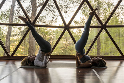 Mature women doing yoga on mat in health retreat