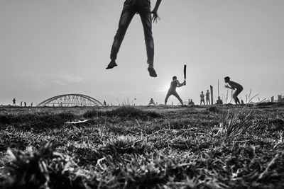 Children playing on field against sky