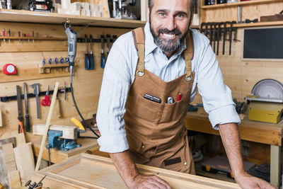 Portrait of smiling carpenter working in workshop