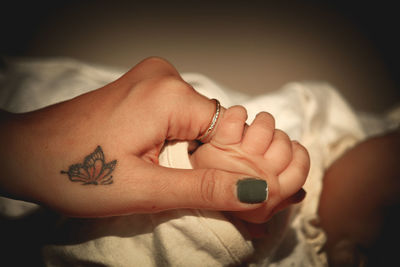 Close-up of woman hand with tattoo on bed