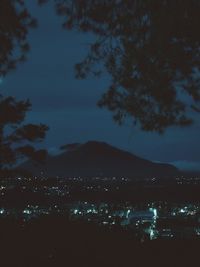 Illuminated cityscape against sky at night