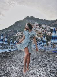 Woman standing on beach against sky