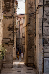 Rear view of people walking on old building