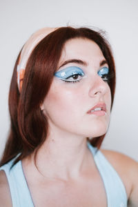 Close-up of young woman against white background