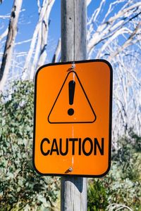 Close-up of road sign on wooden post