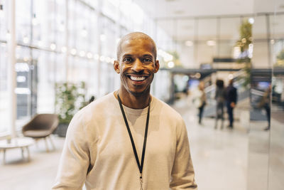 Portrait of smiling mature businessman standing at networking event in convention center