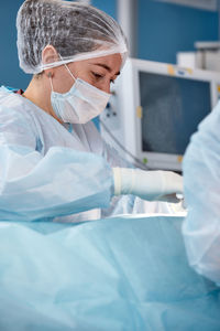 Midsection of doctor examining patient leg in hospital