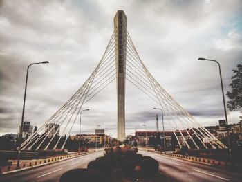 View of suspension bridge against cloudy sky