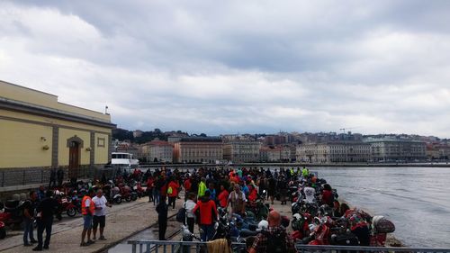 Group of people in city against sky