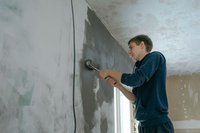 Rear view of man standing against wall