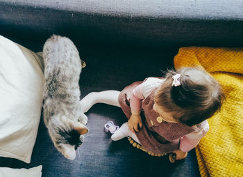 Baby on the sofa in the company of his cat friend