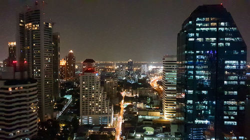 Illuminated buildings in city against sky at night