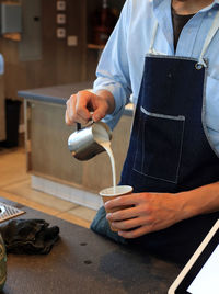 Midsection of man preparing coffee at kitchen