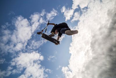 Low angle view of man paragliding against sky