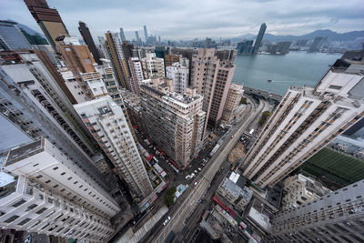 High angle view of buildings in city against cloudy sky