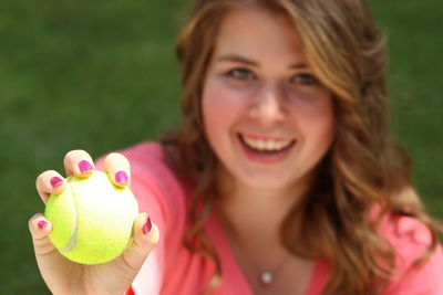 Portrait of smiling young woman holding pink flower