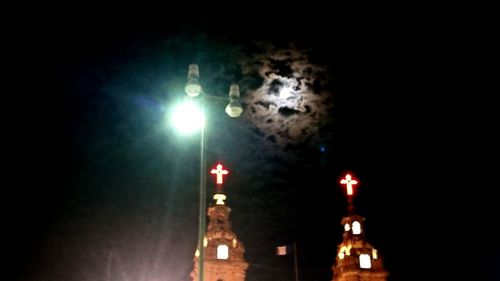 Low angle view of illuminated lights against sky at night