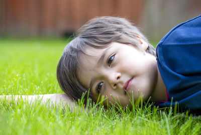 Portrait of cute boy lying on grass