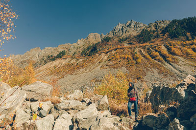 Woman standing on rock against mountain