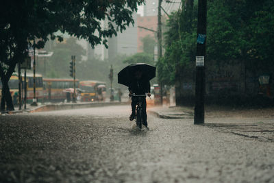 Rear view of man on wet street in city