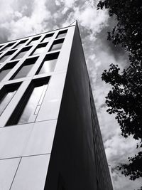 Low angle view of modern building against cloudy sky