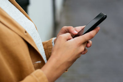 Midsection of man using mobile phone