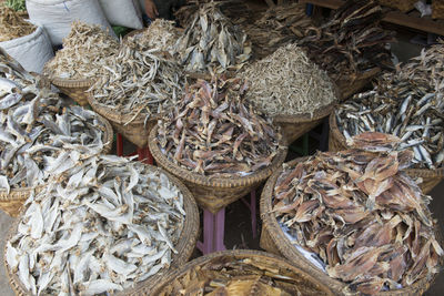 High angle view of dried fish in baskets at market for sale