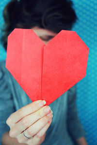 Close-up of hand holding red paper