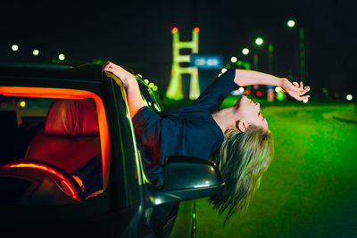 Woman in illuminated clothing in the car at night