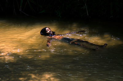 Young woman swimming in lake