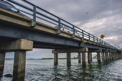Low angle view of bridge over sea against sky