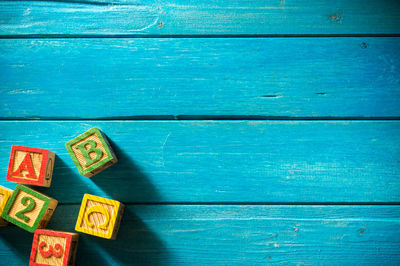 High angle view of colorful toy blocks on blue wooden table