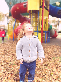 Portrait of young woman standing against trees