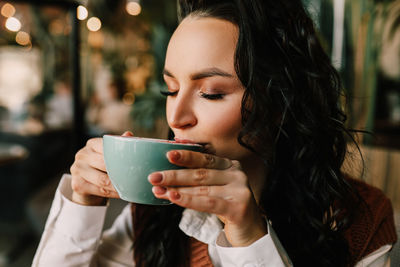 Close-up of woman drinking coffee cup