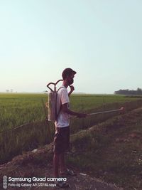 Man standing on field against clear sky