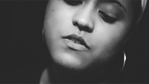 Close-up portrait of teenage girl against black background