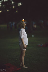 Woman standing on field at night