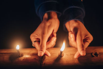 Midsection of man holding burning candle