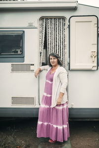 Mature woman standing in front of motor home