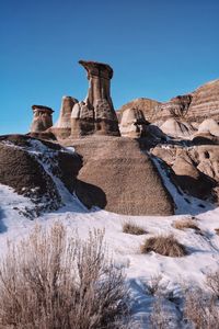 Low angle view of rock formation against clear blue sky