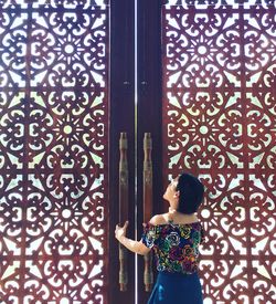 Woman standing against door