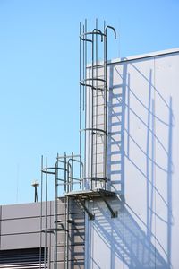 Low angle view of staircase against building against clear blue sky